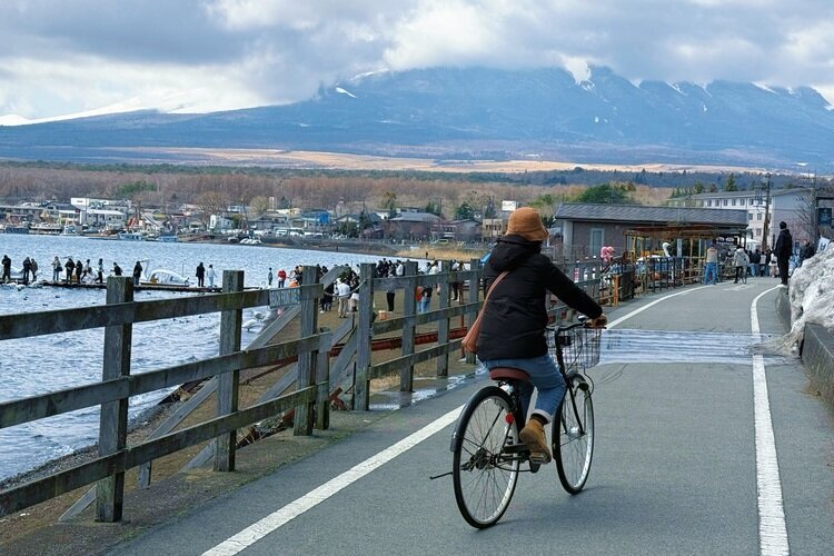 We're biking at Lake Yamanaka, but can't see Mount Fuji due to clouds