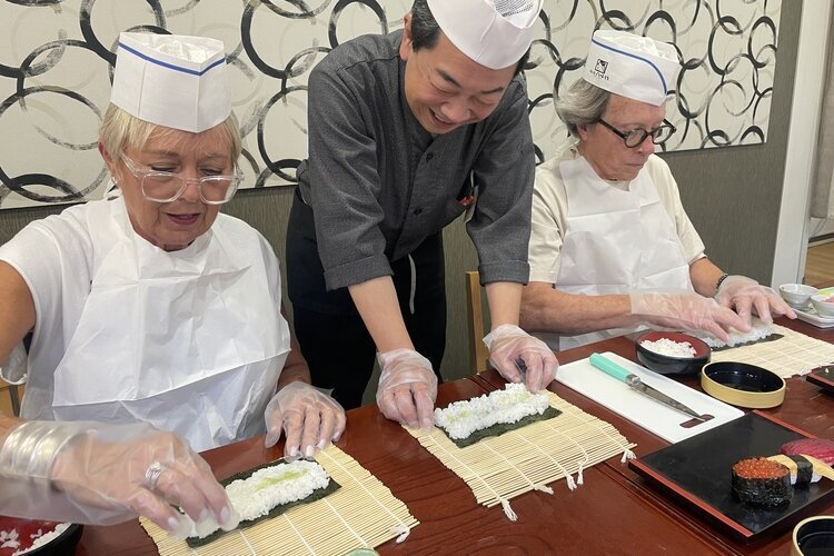 A couple is making sushi with a master in Tokyo